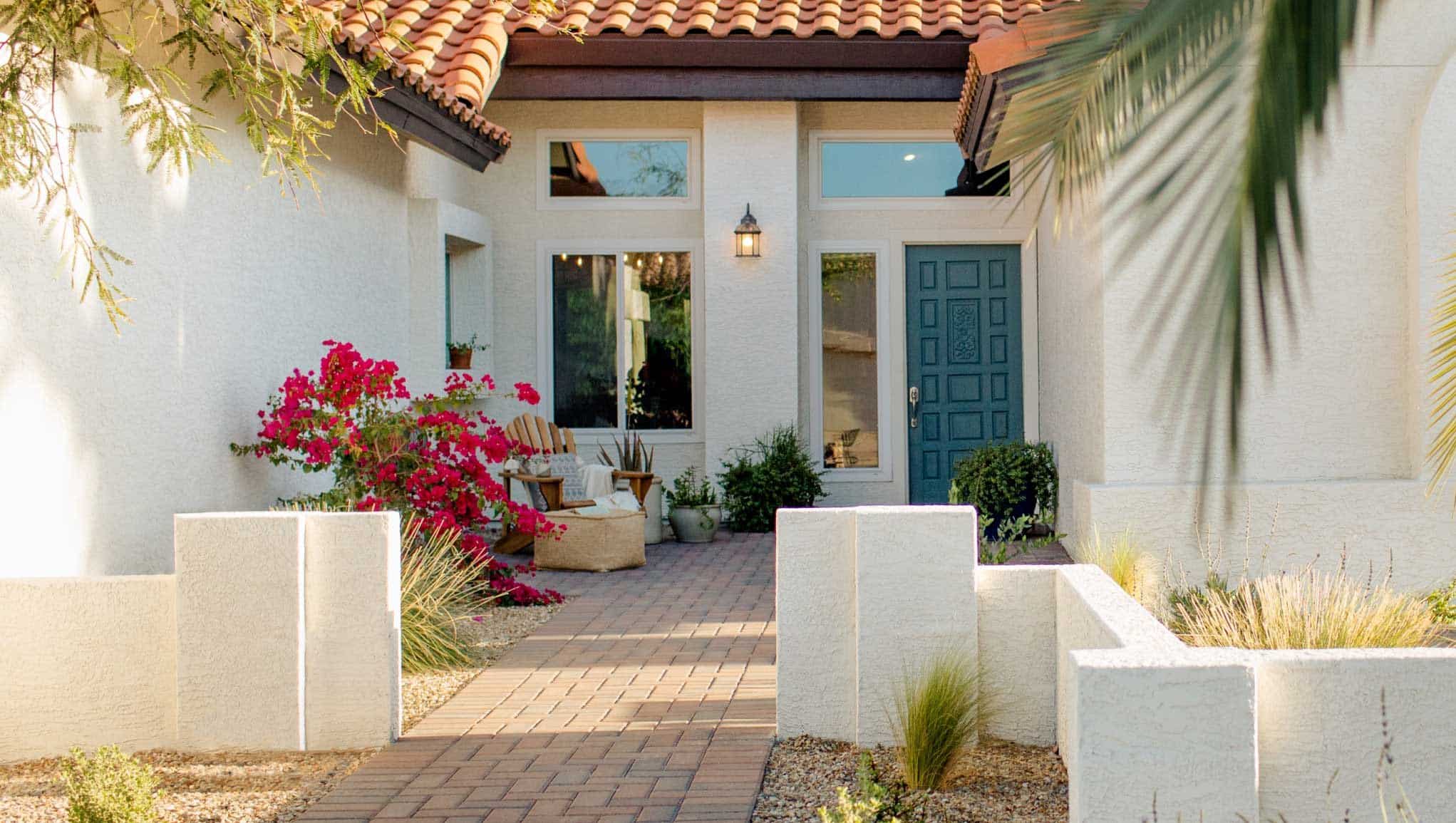 近距离的家庭入口，砖走道，蓝色的前门，和彩色的植物
