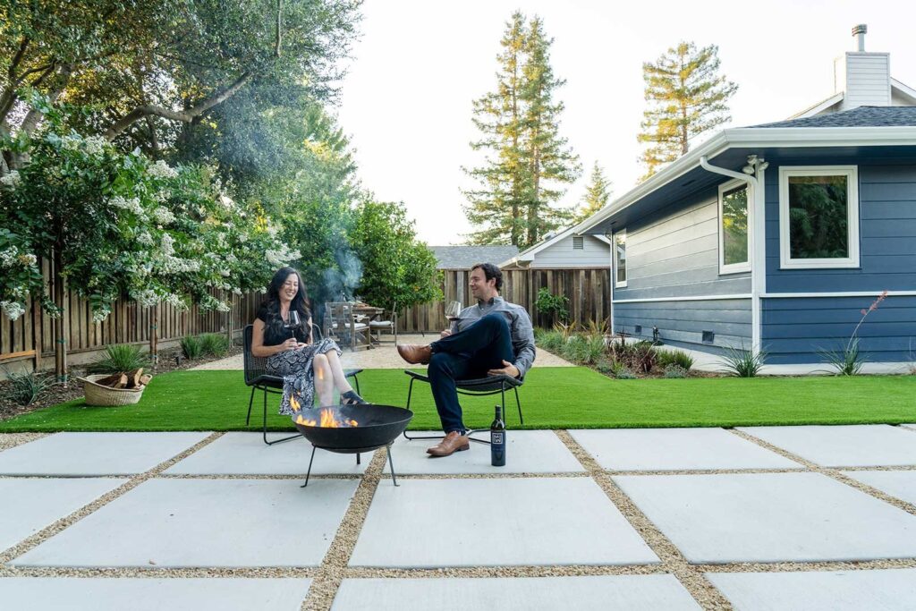 在加州纳帕，一对夫妇在yardzen设计的后院的室外火坑附近享受葡萄酒