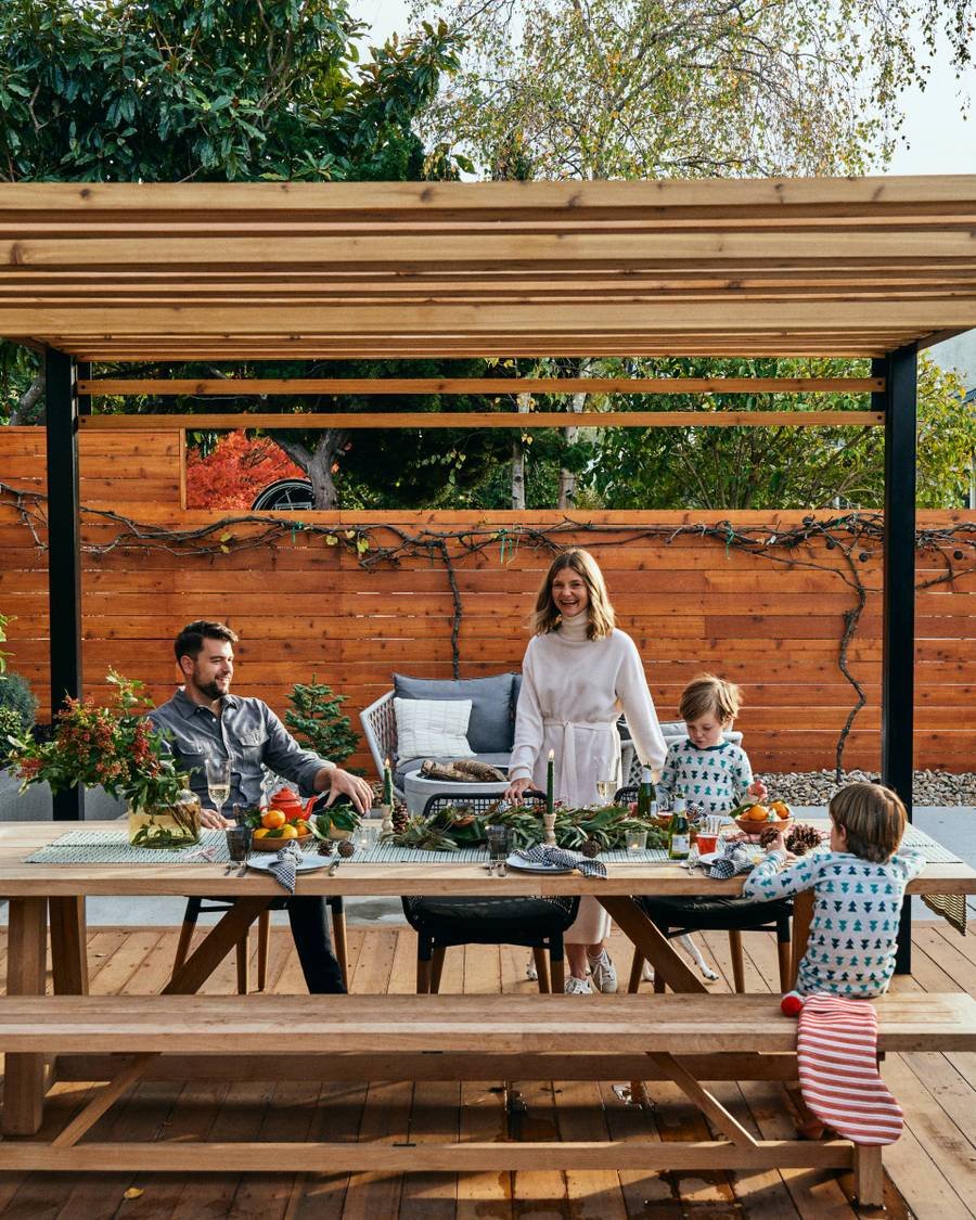黑色金属框架凉棚与定制木板条屋顶的用餐区与一个快乐的家庭