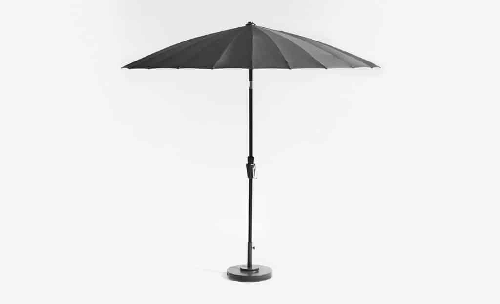 由Crate and Barrel设计的圆顶户外伞，带有黑色遮阳伞形伞盖和黑色框架