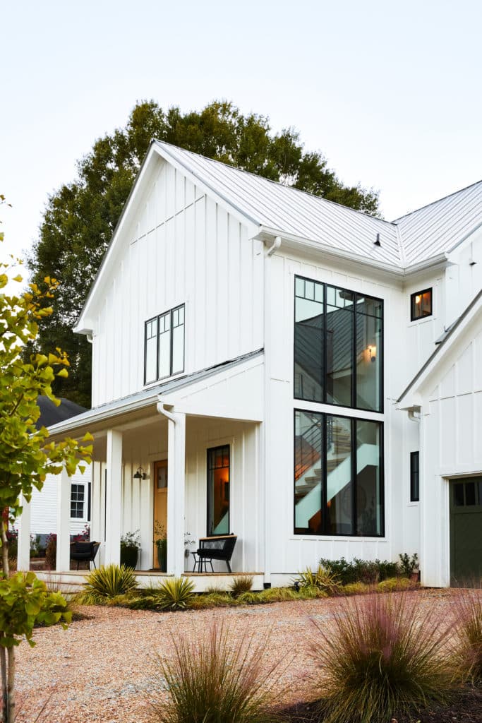 侧视图砾石车道的现代农舍风格的家与大窗户。