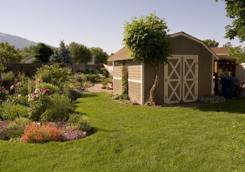 大型传统棚子，周围有植物，可用的草坪和毗邻的庭院