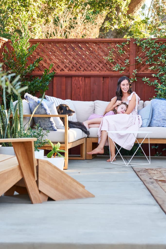 克里斯蒂，她的女儿，和家里的狗享受他们的室外组合式在他们的新混凝土露台。